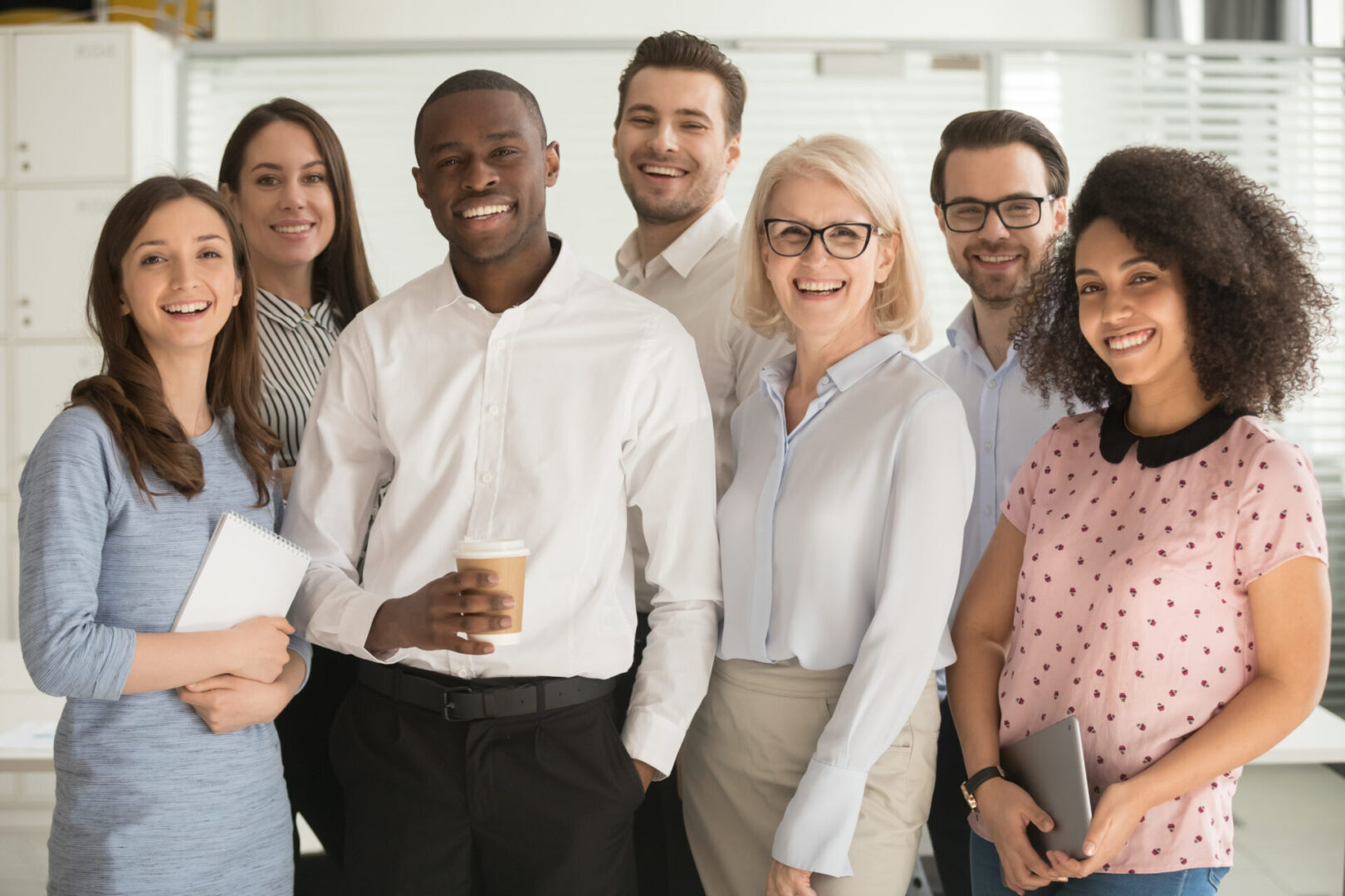 A group of people standing together in front of a wall